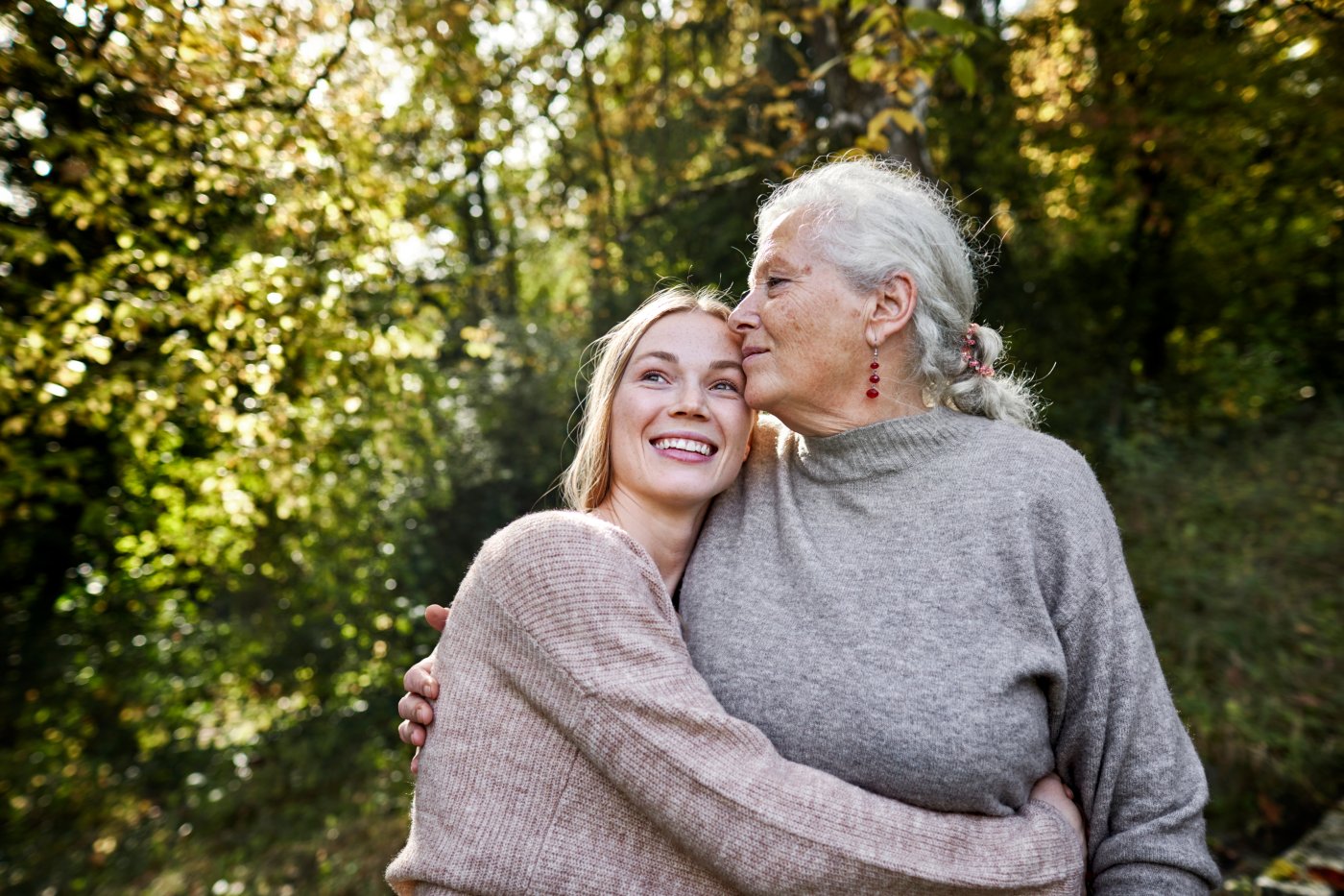 Abuela y nieta abrazándose en un jardín